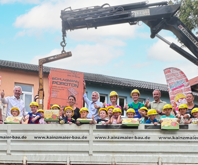 Kindergartentruppe steht auf LKW für Aktion „Baumeister gesucht“